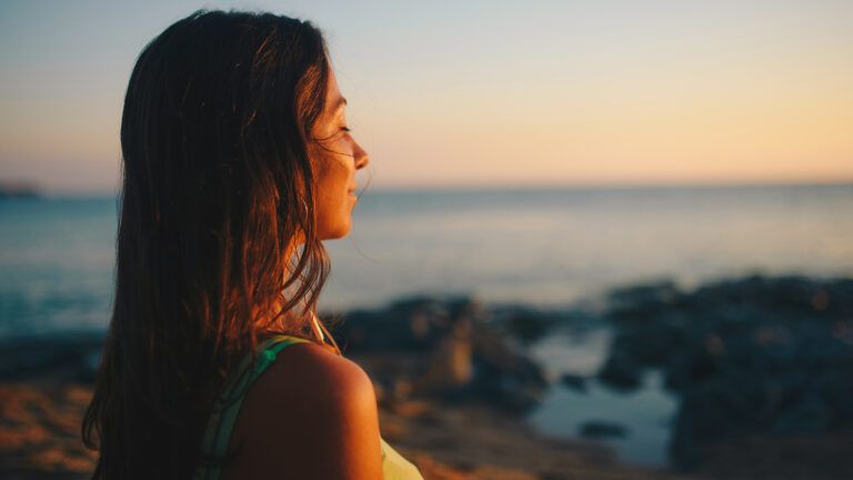 Young woman enjoying the sunrise; Getty Images